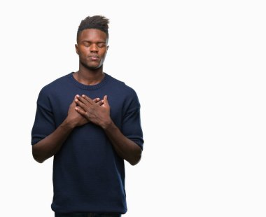 Göğüs kapalı gözler ve yüzünde minnettar jest ile genç Afro-Amerikan adam ile gülümseyen izole arka plan üzerinde eller. Sağlık kavramı.