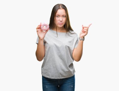 İzole arka tarafına el ve parmak ile işaret çok mutlu üzerinde tatlı çörek yiyen genç kafkas kadın