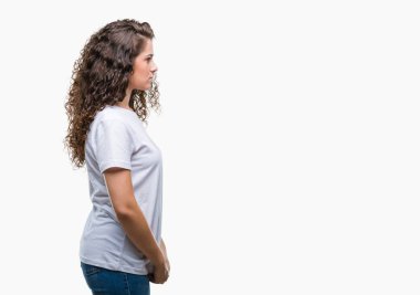 Güzel esmer kıvırcık saçlı Genç kız üzerinde rahat t-shirt giyen arka tarafına, seyir izole dinlenmek doğal yüz emin gülümseme ile pozuyla profili.