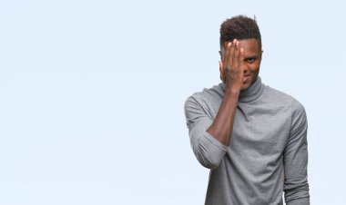 El yüz ve sürpriz duygu kendinden emin gülümseme ile tek gözüyle kapsayan izole arka plan üzerinde genç Afro-Amerikan adam.