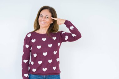 Güzel orta yaş kadın giyiyor kalp kazak izole üzerinde arka plan bir parmak, harika bir fikir ya da düşünce, iyi hafıza ile baş gösteren gülen