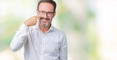 Yakışıklı orta yaş zarif üst düzey iş adam gözlük izole üzerinde işaretleme için yüz ve burun, neşeli gülümseyerek el parmak ile arka plan