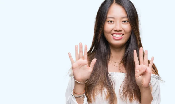 孤立した背景表示と指で上向きに若いアジア女性ナンバー ナイン自信を持って 幸せな笑みを浮かべて — ストック写真