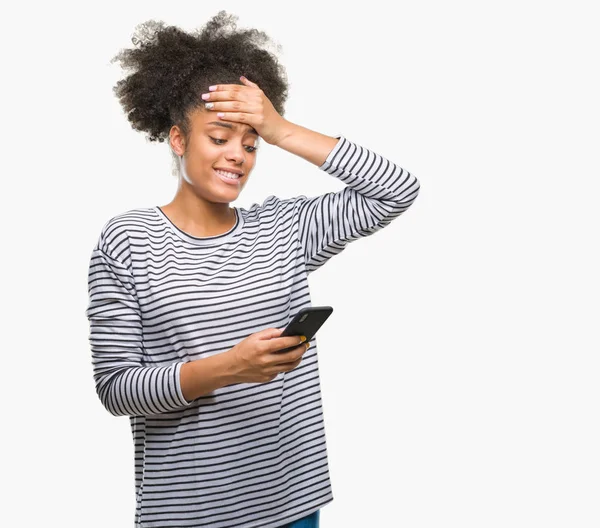 Baş, el ile vurguladı izole arka plan üzerinde Smartphone kullanarak genç afro Amerikalı kadın manifatura şok utanç ve sürpriz suratla, öfkeli ve sinirli. Korku ve hata için üzgün.