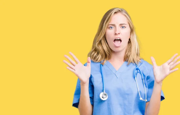 上医療ユニフォーム身に着けている美しい若い医師女性狂気の背景を分離し 怒って叫んで 叫んで積極的な表現と腕を上げます 欲求不満のコンセプト — ストック写真