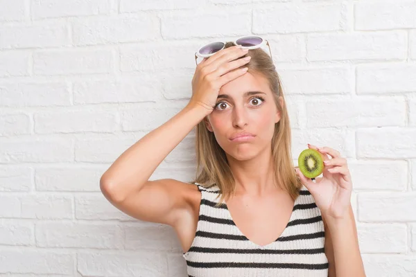 Schöne Junge Frau Über Weiße Backsteinmauer Essen Grüne Kiwi Gestresst — Stockfoto