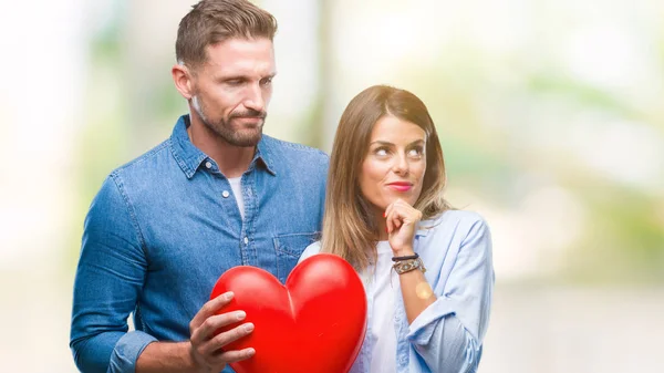 Jovem Casal Apaixonado Segurando Coração Vermelho Sobre Fundo Isolado Rosto — Fotografia de Stock