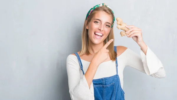 Hermosa Mujer Joven Sobre Pared Gris Grunge Sosteniendo Jengibre Fresco — Foto de Stock