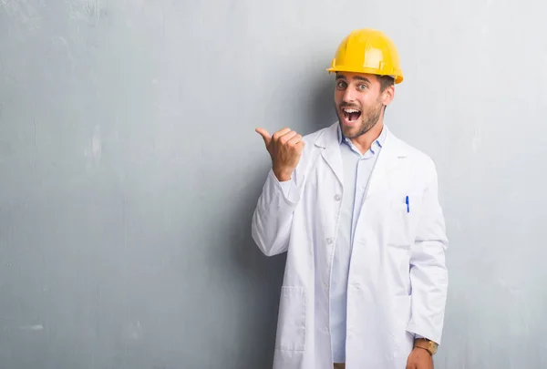 Guapo Joven Ingeniero Hombre Sobre Gris Grunge Pared Usando Casco —  Fotos de Stock