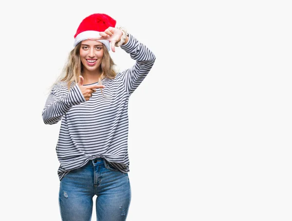 美しい若い金髪女性の笑顔と幸せそうな顔で指手作りフレーム分離の背景にクリスマス帽子をかぶっています 創造性と写真のコンセプト — ストック写真