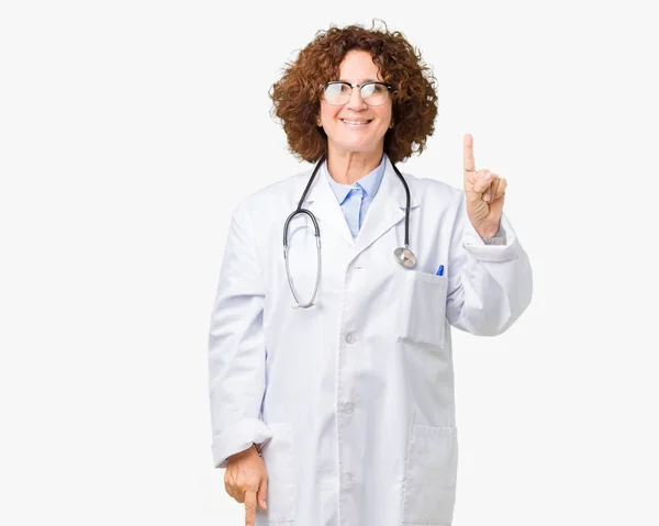 中间的资深医生妇女在孤立的背景显示和指向手指第一 同时微笑着自信和快乐 — 图库照片