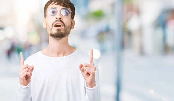 Jovem Homem Bonito Usando Óculos Sol Sobre Fundo Isolado Espantado — Fotografia de Stock