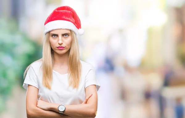 年轻美丽的金发女子圣诞节帽子在孤立的背景怀疑和紧张 反对的表情在脸上交叉的胳膊 消极的人 — 图库照片