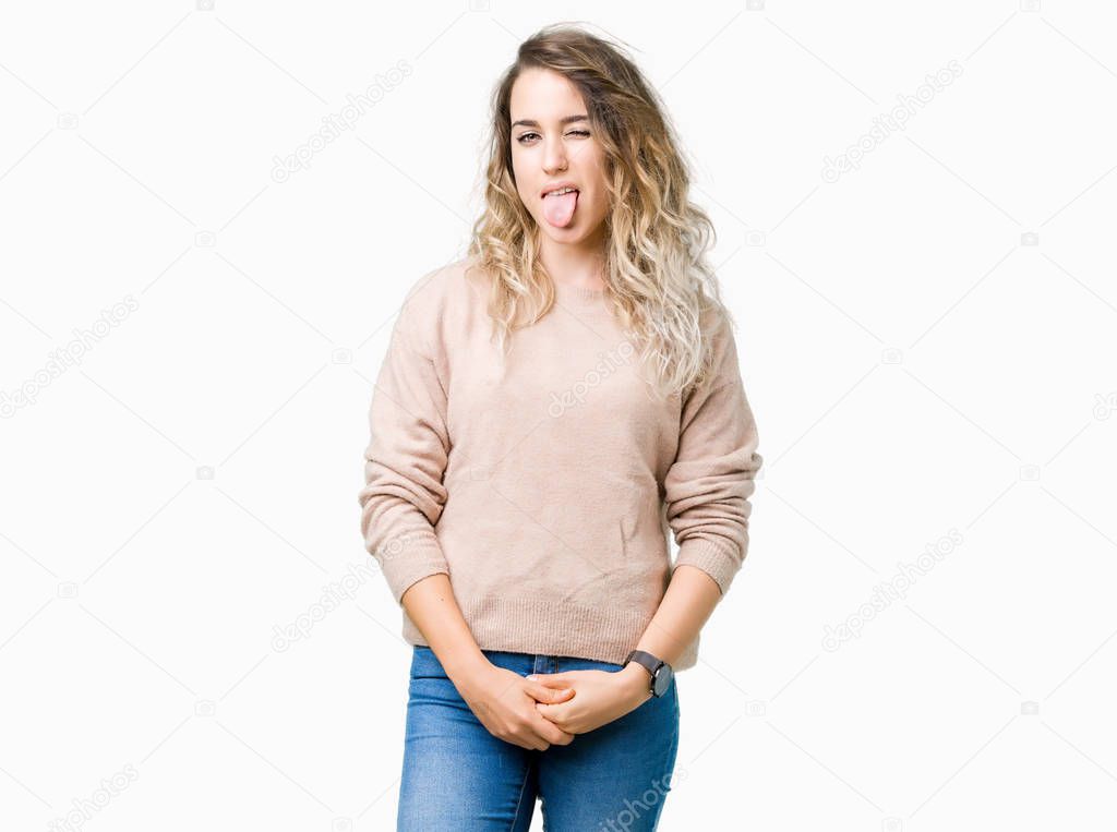 Beautiful young blonde woman wearing sweatershirt over isolated background sticking tongue out happy with funny expression. Emotion concept.