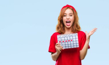 İzole arka plan büyük gülümseme ile çığlık zaferini kutluyor ve ellerini kaldırdı adet takvim çok mutlu ve heyecanlı, kazanan ifade tutan genç güzel kadın