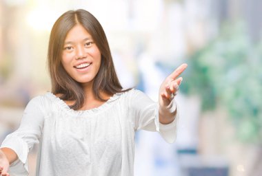 Sarılmak için kollarını açarak gülümseyerek kameraya bakarak izole arka plan üzerinde Genç Asyalı kadın. Neşeli ifade kucaklayan mutluluk.