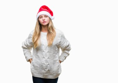 Yüzünde ciddi bir ifade ile izole arka plan üzerinde Noel şapka giyen genç güzel sarışın kadın. Basit ve doğal kameraya bakıyor.