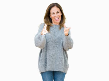 El ile pozitif jest yapıyor onaylama izole arka plan üzerinde kış kazak giyen güzel orta yaş kadın başparmak gülümseyen ve başarı için mutlu. Kamera, kazanan jest arıyorsunuz.