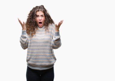 İzole arka plan kutlama üzerinde kış kazak kızgın ve silah ile başarı için deli giyen genç kız kaldırdı ve heyecanlı çığlık gözleri kapalı güzel esmer kıvırcık saçlı. Kazanan kavramı