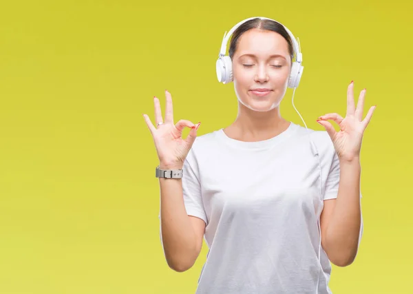 Jovem Caucasiana Ouvindo Música Usando Fones Ouvido Sobre Fundo Isolado — Fotografia de Stock