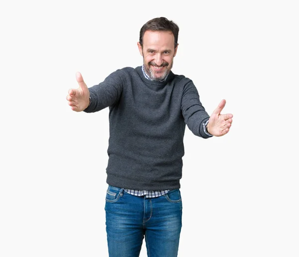 英俊的中年男子穿着一件毛衣在孤立的背景看着镜头微笑着张开双臂拥抱 拥抱幸福的快乐表情 — 图库照片