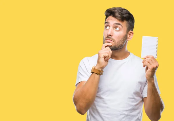 Joven Hombre Guapo Sosteniendo Cuaderno Sobre Fondo Aislado Cara Seria — Foto de Stock