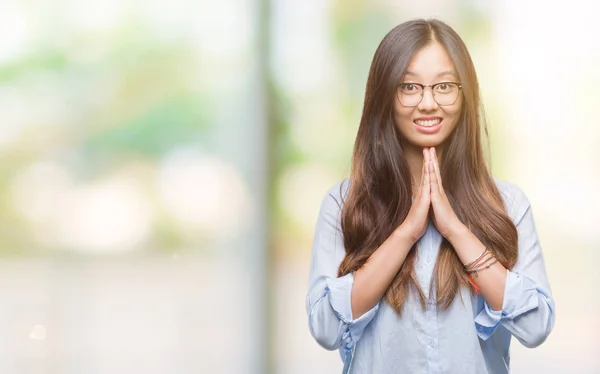 年轻的亚洲商业妇女戴着眼镜在孤立的背景祈祷双手一起祈求原谅微笑自信 — 图库照片