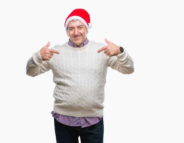 ハンサムな年配の男性の顔に笑顔と自信を持って 誇りと幸せな指で自分を指している孤立した背景にクリスマスの帽子をかぶって — ストック写真