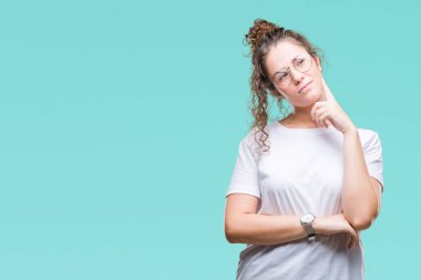 Güzel genç esmer kıvırcık saçlı kız gözlüklü üzerinde arka plan çene düşünme hakkında soru, dalgın ifade üzerine el ile izole. Düşünceli yüzüyle gülümsüyor. Şüphe kavramı.