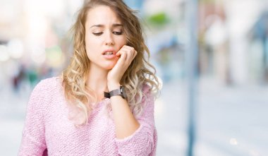 Güzel sarışın genç kadın stresli ve gergin ile eller tırnak ısırma dudaklarından seyir izole arka plan üzerinde. Anksiyete sorunu.