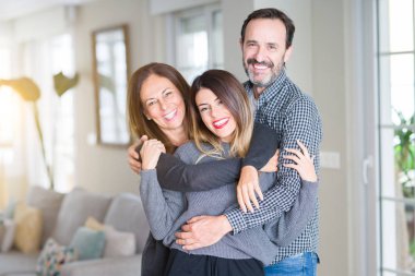 Güzel aile birlikte. Anne, baba ve kızı gülümseyen ve evde sevgi ile sarılma.