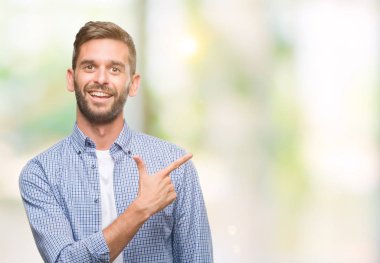 İzole arka neşeli bir gülümseme ile el ve parmak kadar kameraya bakarak yüzündeki mutlu ve doğal ifade ile yan ile işaret yüz üzerinden beyaz t-shirt giyen genç yakışıklı adam.