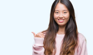 Genç Asyalı kadın arıyorum ve başparmak yanında yukarıyı mutlu yüz ile gülümseyen izole arka plan üzerinde.