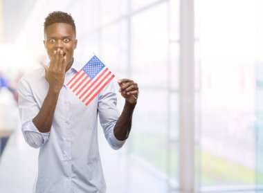 ABD bayrağı kapak ağız hata, korku, sessizlik içinde gizli kavramı korkmuş ifade için utanç ile şok eliyle tutan genç Afro-Amerikan adam