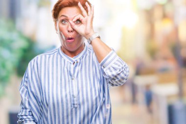 Sürpriz yüz, göz parmaklarının arasından seyir ile Atrractive üst düzey beyaz Kızıl saçlı kadın Tamam jest yapıyor izole arka plan yüzünden şok. İmansız ifade.