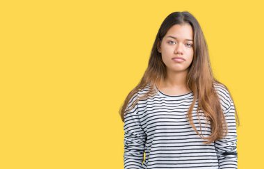 Üzerinde çizgili süveter giyen genç güzel esmer kadın arka plan gevşek yüzünde ciddi bir ifade ile izole. Basit ve doğal kameraya bakıyor.