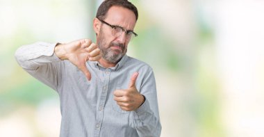 Üzerinde gözlük takan yakışıklı orta yaş zarif komuta sizde arka plan yapmaya başparmak yukarı ve aşağı anlaşmazlık ve anlaşma ifade izole. Deli çatışma