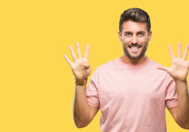 Yakışıklı delikanlı gösterilen ve parmakları ile işaret izole arka plan üzerinde numara 9 kendinden emin ve mutlu gülümseyerek süre.