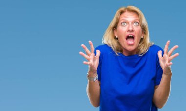 Orta yaş sarışın kadın izole arka plan çılgın ve kızgın bağırarak ve agresif ifade ve silah kaldırdı bağırıyor. Hayal kırıklığı kavramı.