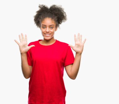 Gösterilen ve parmakları ile işaret izole arka plan üzerinde genç afro Amerikalı kadın kendinden emin ve mutlu gülümseyerek süre on numara.