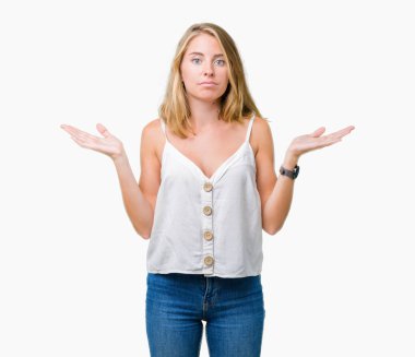 Güzel genç kadın yüzünden izole arka plan clueless ve şaşkın bir ifadeyle kollar ve eller kaldırdı. Şüphe kavramı.