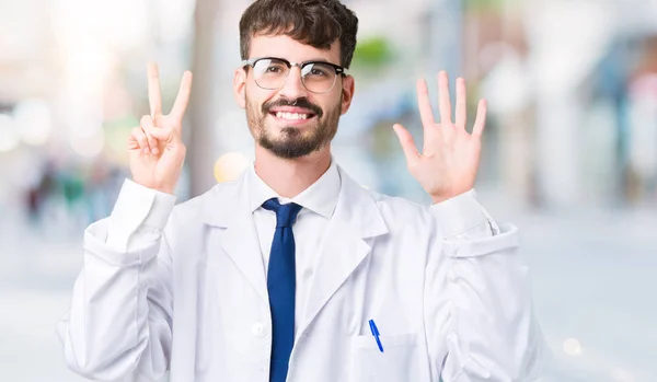 年轻的专业科学家男子穿着白色外套在孤立的背景显示和手指指向七 同时微笑着自信和快乐 — 图库照片