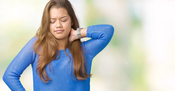 バック グラウンドの分離に青いセーターを着ている若い美しいブルネットの女性手 筋肉痛と首に触れる首の痛みけがの苦しみ — ストック写真