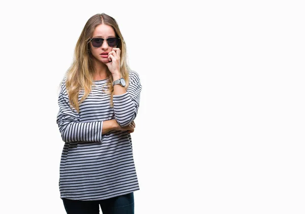 年轻美丽的金发女子戴着太阳镜在孤立的背景下看紧张和紧张与手在嘴咬指甲 焦虑问题 — 图库照片