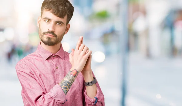 Joven Hombre Guapo Con Camisa Rosa Sobre Fondo Aislado Sosteniendo —  Fotos de Stock