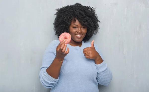 Junge Afrikanisch Amerikanische Frau Über Graue Grunge Wand Essen Rosa — Stockfoto