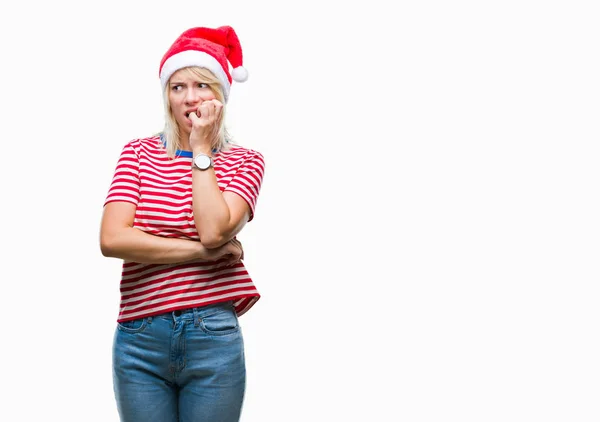 年轻美丽的金发女子戴着圣诞节帽子在孤立的背景下看紧张和紧张与手在嘴咬指甲 焦虑问题 — 图库照片