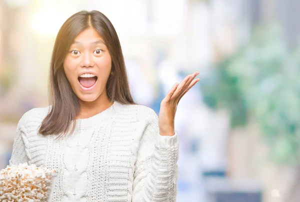 ポップコーン食べて分離背景非常に幸せと興奮 勝者式笑顔で叫んで勝利を祝ってと手を上げた若いアジア女性 — ストック写真
