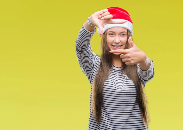 年轻美丽的白人妇女戴着圣诞节帽子在孤立的背景微笑制作框架用手和手指与快乐的脸 创意与摄影理念 — 图库照片