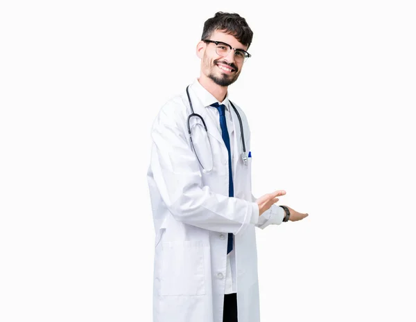 Joven Doctor Vistiendo Abrigo Hospital Sobre Fondo Aislado Invitando Entrar —  Fotos de Stock